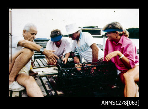 35mm colour transparency of four people sitting on a boat next to a pearl cage