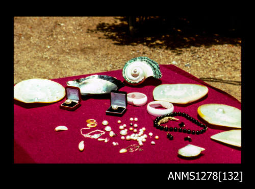 35mm colour transparency of pearls, pearl jewellery, pearl shells and shells on a red table cloth