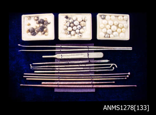 35mm colour transparency of pearl seeding tools and pearls in three display boxes