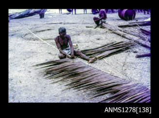 35mm colour transparency of a man weaving leaves