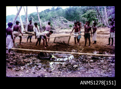 35mm colour transparency of numerous Papua New Guinean men, possibly sifting dirt