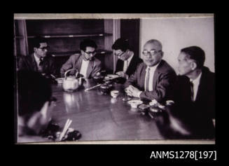 Japanese men sitting around a table