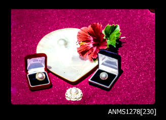 35mm colour transparency of a pearl shell with a blister pearl, three pieces of pearl jewellery, two in jewellery boxes, and a hibiscus flower