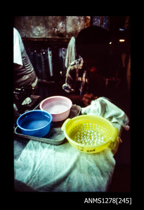 35mm colour transparency of a three buckets (pink, blue and yellow) in a shed, with pearls in the yellow bucket