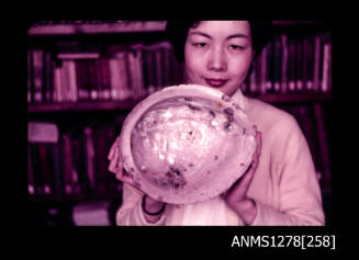 35mm colour transparency of a Japanese woman holding a large shell