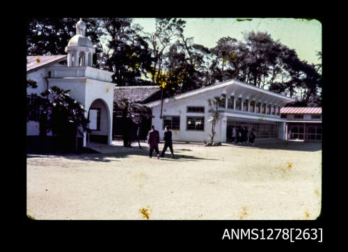 35mm colour transparency of two men standing outside a white building