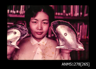 35mm colour transparency of a Japanese woman holding up two pearl shells