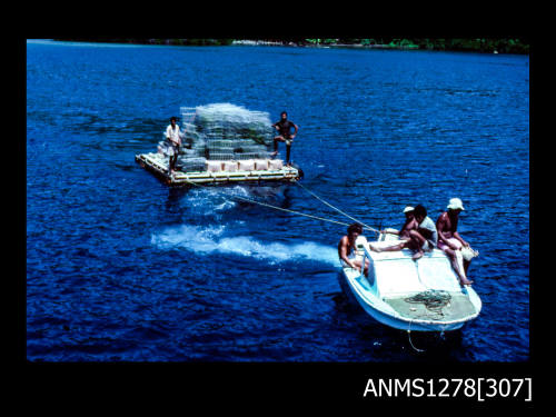 35mm colour transparency of a motor boat pulling a barge carrying pearl cages