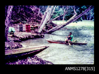 35mm colour transparency of a person and child in a canoe near the shoreline