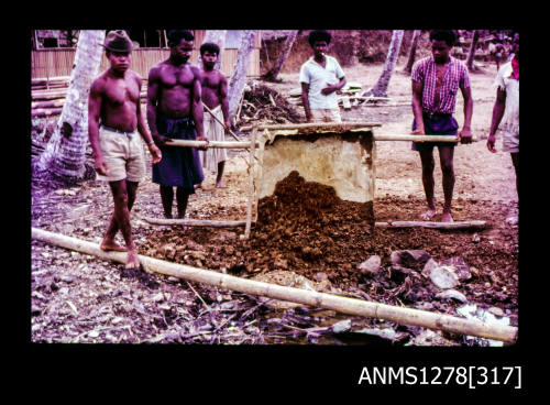 35mm colour transparency of Several Papua New Guinean men moving dirt