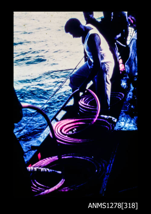 35mm colour transparency of people on a boat, one of whom is holding onto a red hose