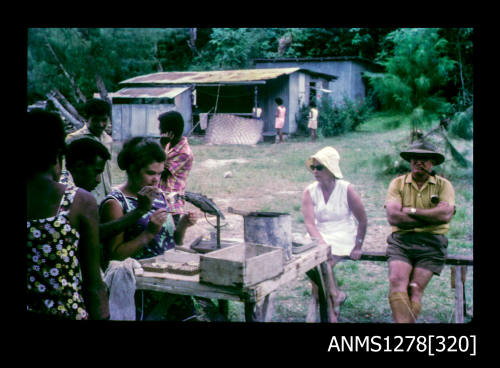 35mm colour transparency of people watching a woman seed a pearl shell