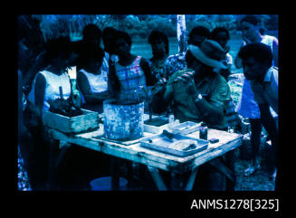 35mm colour transparency of Papua New Guinean people standing around a table with pearling equipment