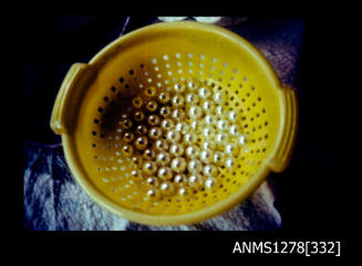 35mm colour transparency of a yellow sieve partially filled with pearls