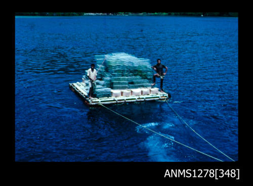 35mm colour transparency of a raft, carrying two men and a large pile of pearl cages, attached to two ropes