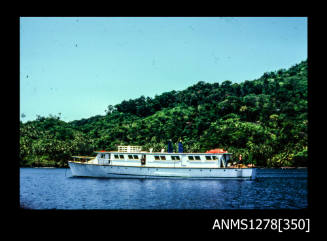 35mm colour transparency of a white boat in the water, in front of land