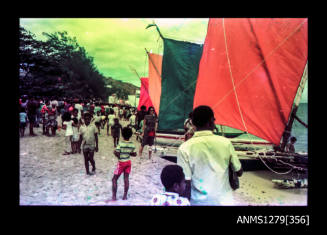 Strip with one colour negative of people standing on the beach during the Pacific Festival on Pearl Island, with boats with coloured sails on the sand