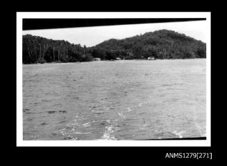 A pearl raft near the shoreline, on which are two sheds, or houses