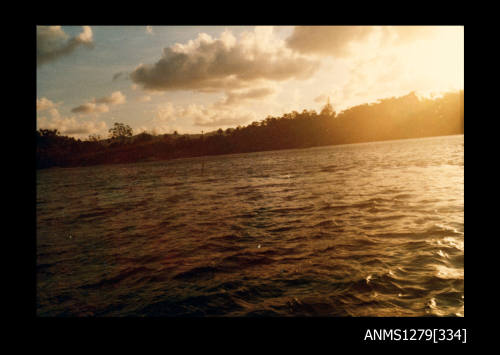 Colour photograph of land and water, taken from a boat, on Pearl Island