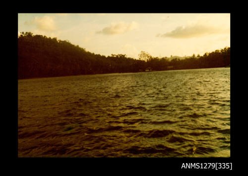 Colour photograph of land and water, taken from a boat, on Pearl Island