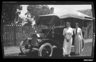 Two unidentified women, possibly related to Captain Edward R Sterling, standing beside a car