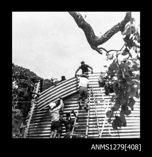 Photograph of several men constructing something out of corrugated iron