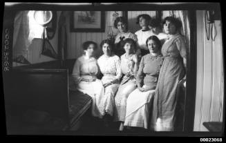 Eight unidentified women, possibly related to Captain Edward R Sterling, in a loungeroom