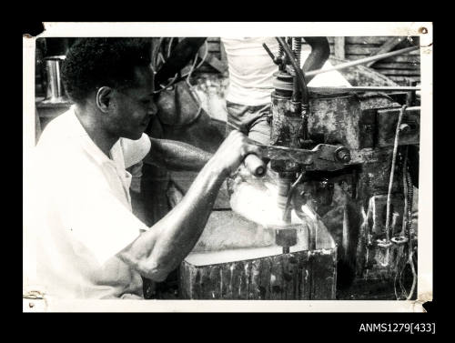 A Papua New Guinean man using a pearl shell cutting machine