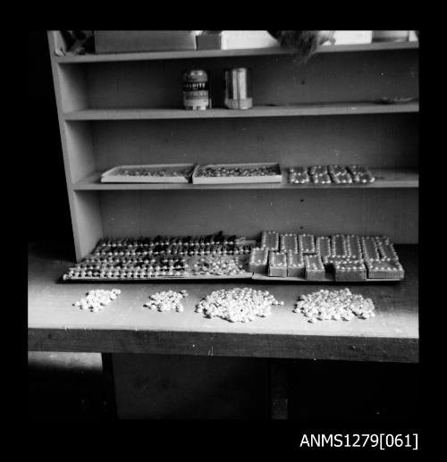 A desk with containers, half pearls (or mabe pearls) and nuclei