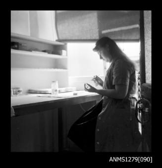 A woman sitting at a desk using an air brush