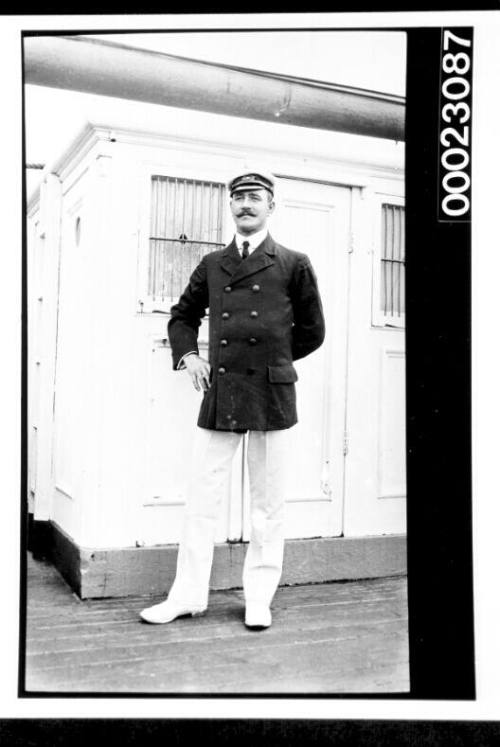 Unidentified man standing in front of cabin