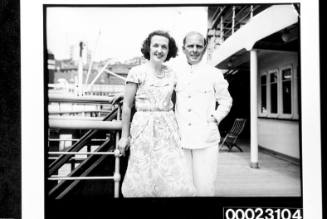 Unidentified woman and crew member posing on board RMS CARONIA