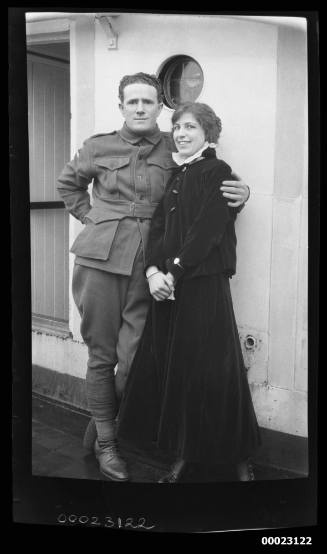 Unidentified man and woman standing near a porthole