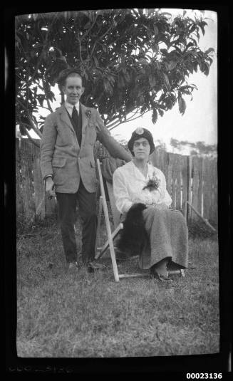 A man and a woman, possibly related to Captain Edward R Sterling, near a tree