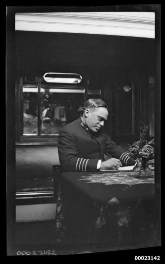 Unidentified officer seated in the saloon on board the six-masted barquentine E R STERLING