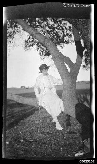 Woman sitting on a tree branch