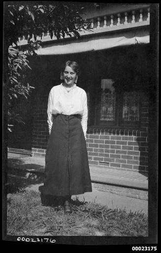 Woman standing in front of a brick house