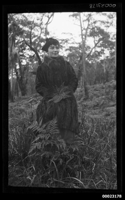 Woman in fur coat standing in landscape