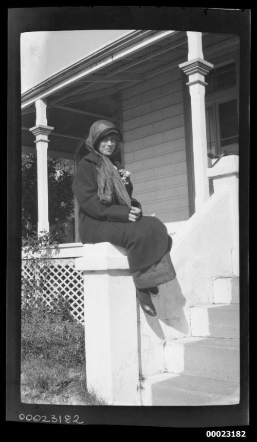 Woman sitting on front steps of a house