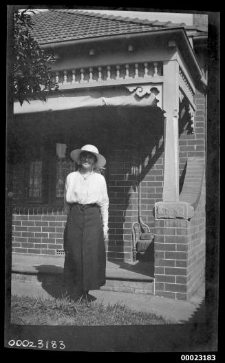 Woman standing in front of a brick house