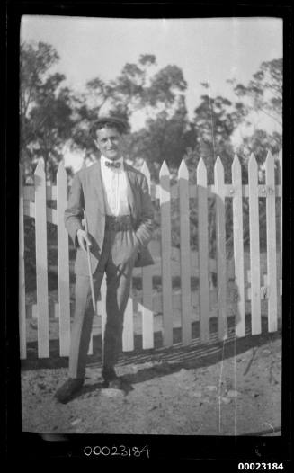 Man standing in front of a picket fence