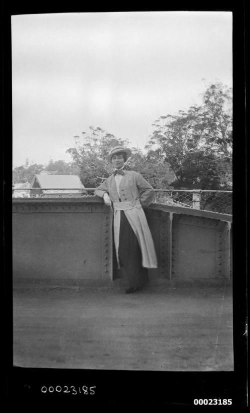 Woman standing in front of a metal fence