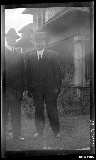 Two men standing in front of a house