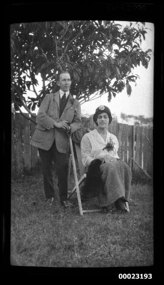 Man and woman sitting on foldup canvas chair on a lawn