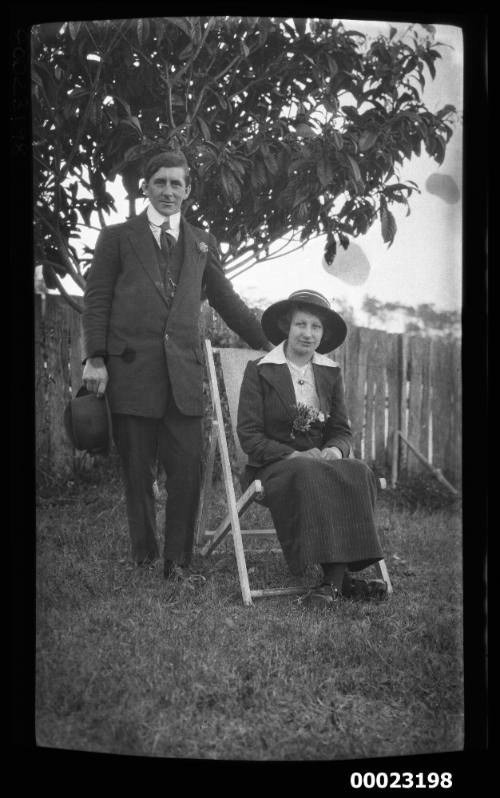 Man and woman sitting on foldup canvas chair on a lawn