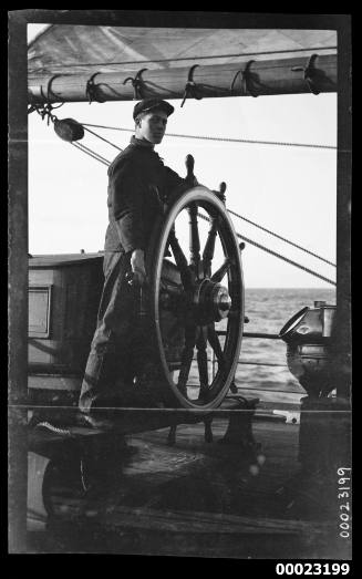 Man standing at a ship's wheel