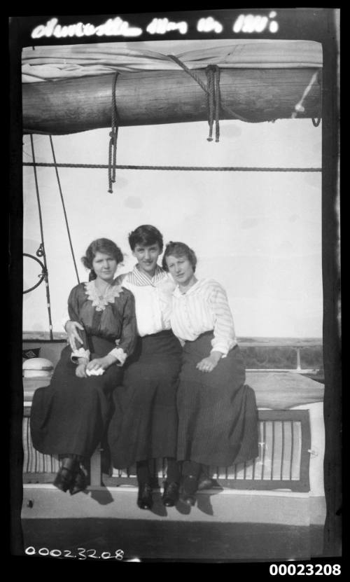 Three unidentified women sitting beneath a boom