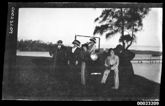 Four women and two men around a car