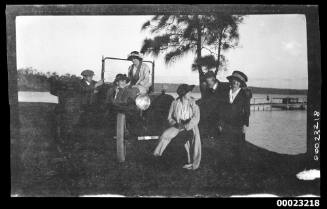 Four women and two men around a car