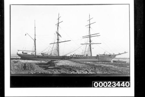 Image of the vessel EDINBURGH being ballasted by the side of a rocky bank